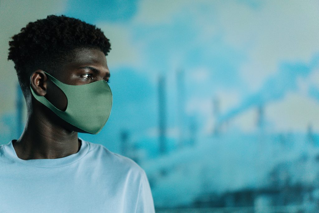 black man wearing mask with air pollution in the background